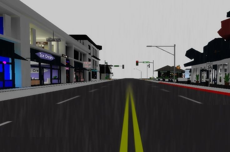 an animated view of a city street with buildings on both sides and traffic lights in the distance