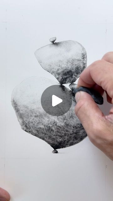 someone is drawing an apple on paper with black marker and white background, while another hand holds a pen