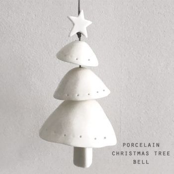 a white ceramic christmas tree ornament hanging from a hook