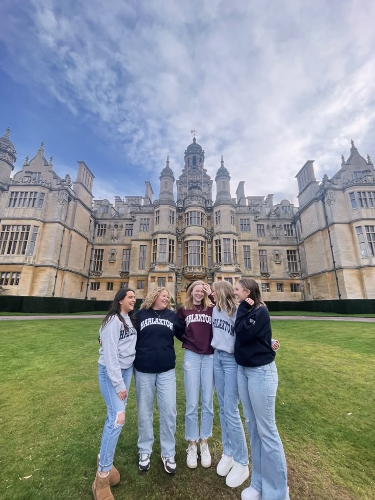 four girls standing in front of a large building