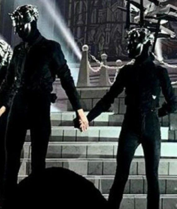 two people holding hands in front of a stage