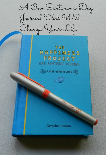 a pen sitting on top of a blue book next to a notepad with the words, a one sentence a day journal that will change your life