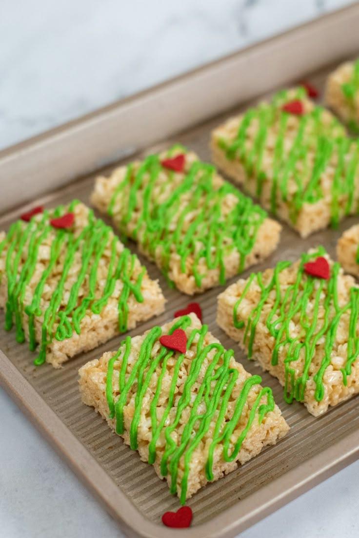 green sprinkled rice krispy treats on a baking sheet with red and white hearts