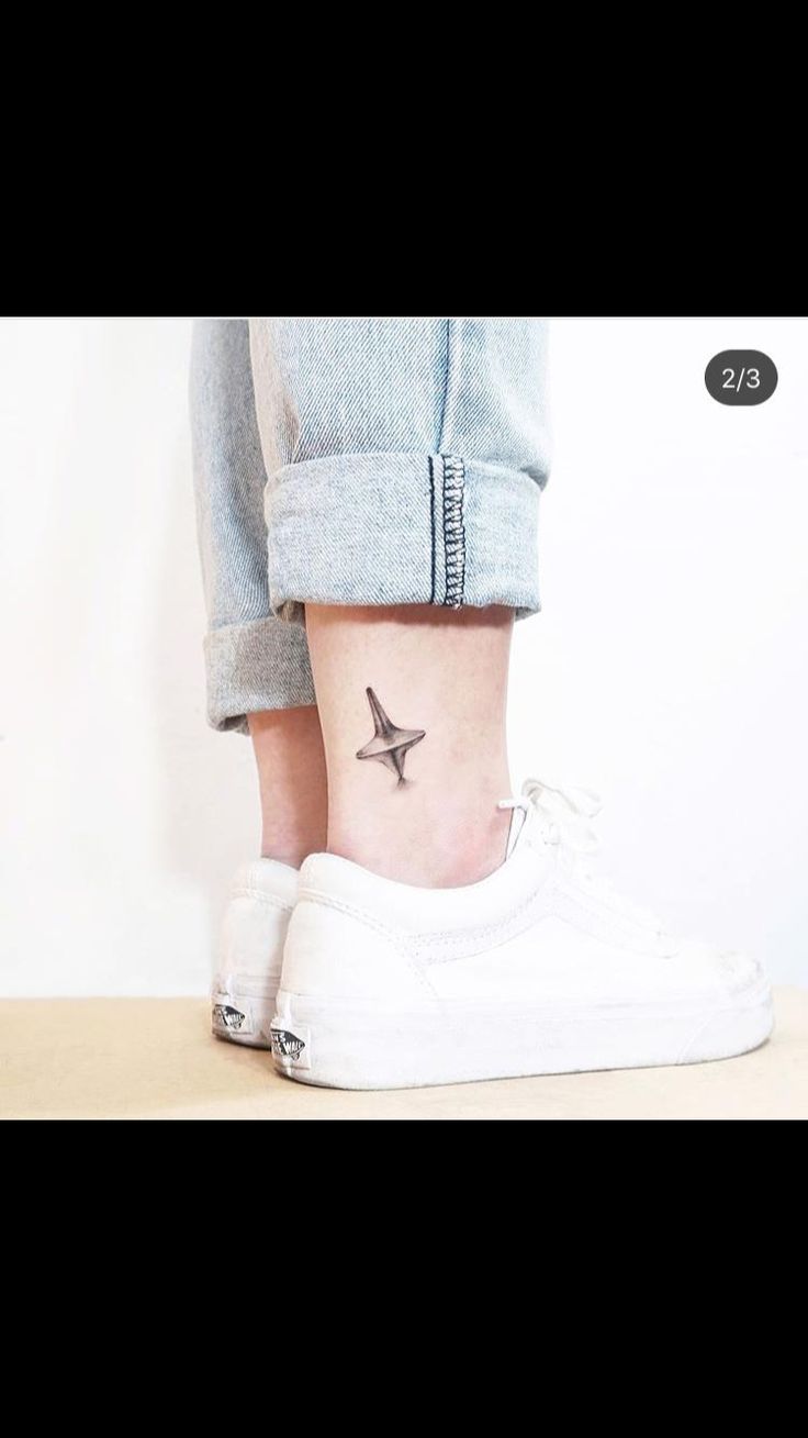 a person with a small bird tattoo on their ankle