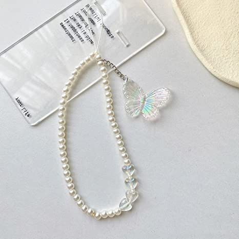 a white necklace with a butterfly on it and a tag attached to the bead