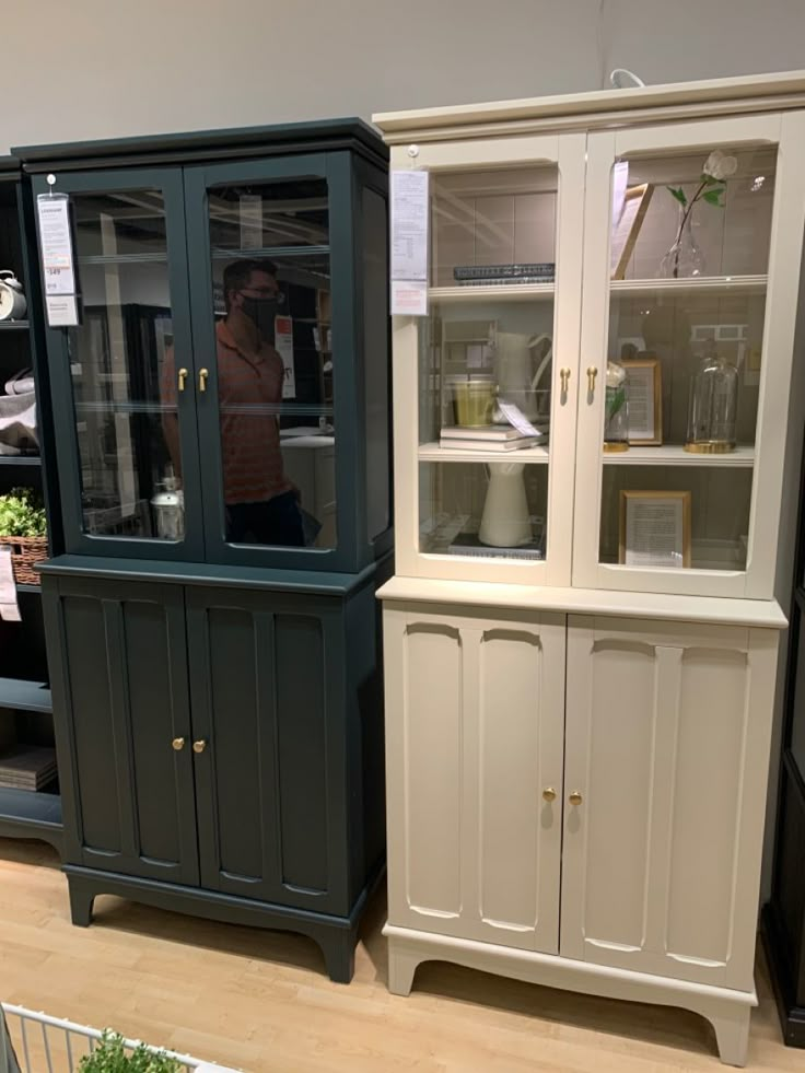 two china cabinets with glass doors on each side and shelves in the middle, along with other pieces of furniture