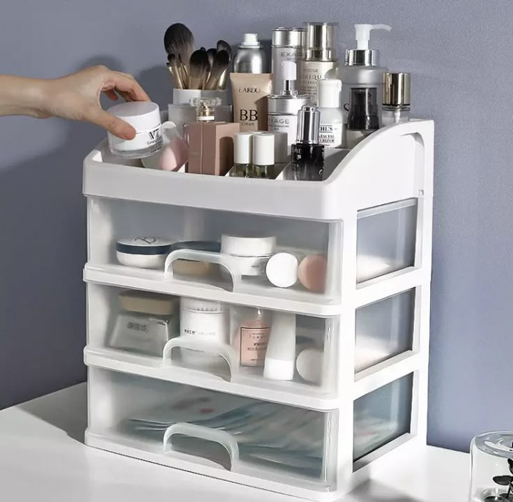 a person holding a container with various items in it on top of a white table