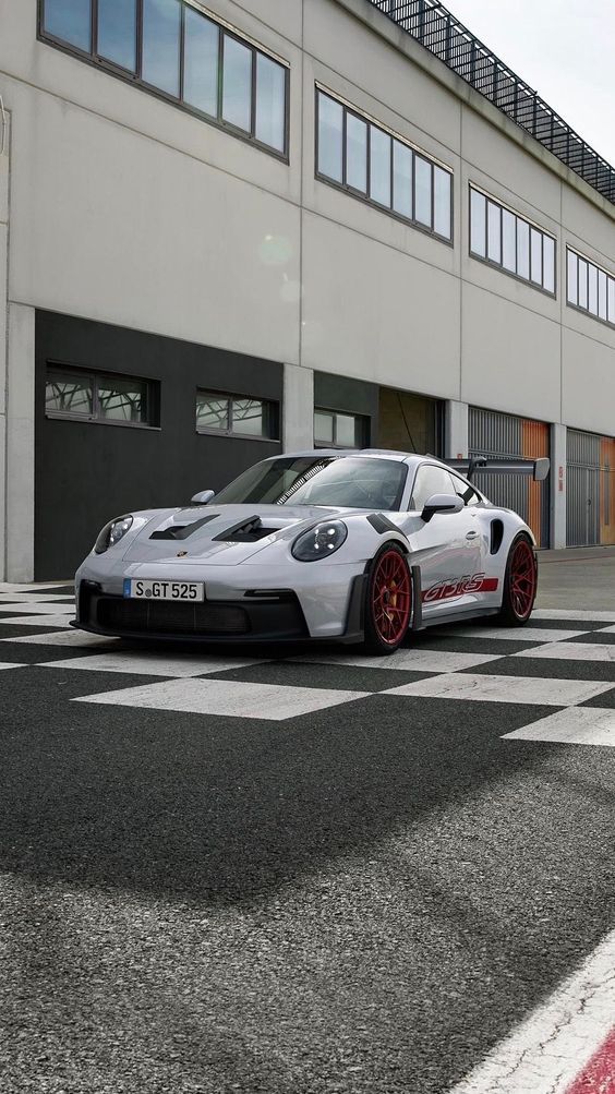 a white sports car parked in front of a building