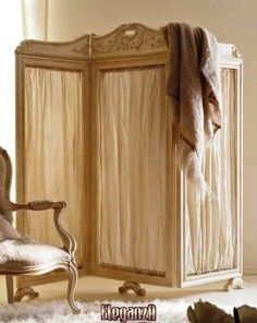 an old fashioned crib in a room with a chair and rug on the floor