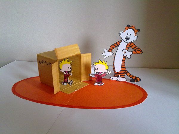 an orange and white paper cut out of a cartoon character with a cat in a box