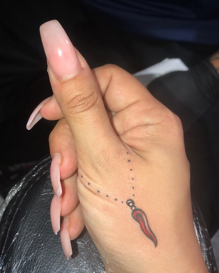 a woman's hand with a small tattoo on it