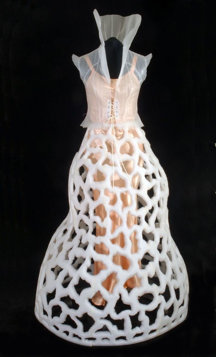 a dress made out of white plastic on a black background with the image of a giraffe's head