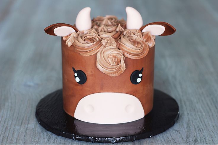 a chocolate cake decorated with flowers and a cow's head