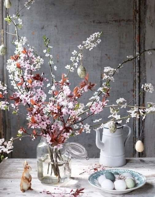 a vase filled with flowers and eggs on top of a table