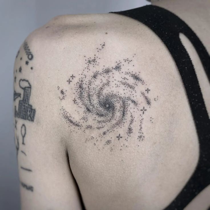 the back of a woman's shoulder with stars and a spiral design on it