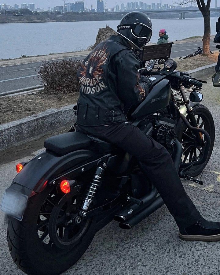 a man sitting on his motorcycle in the street