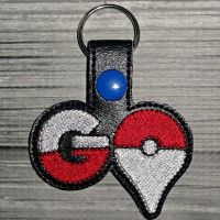 a close up of a keychain with a pokemon logo on the front and back