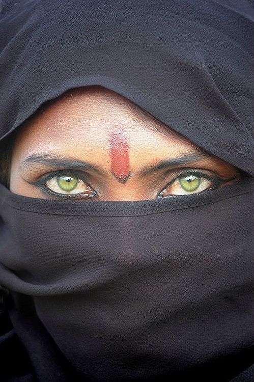 a woman with green eyes wearing a black veil