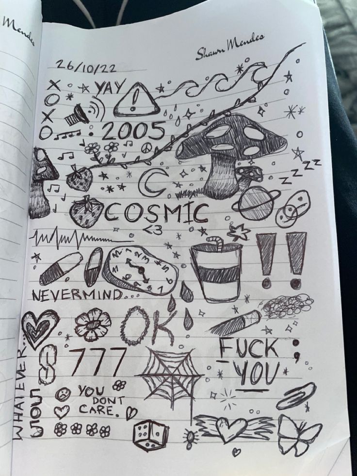 someone is holding up a notebook with doodles on it and writing in the pages