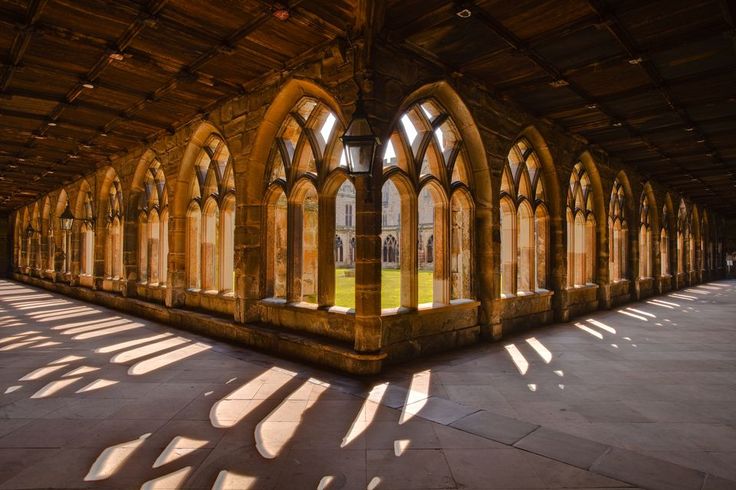 the sun shines through windows in an old building with stone floors and arches on each side