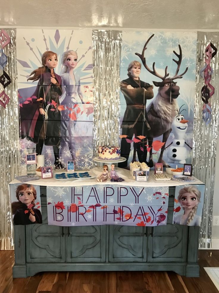 a frozen princess birthday party with decorations and food on the buffet table in front of an ice queen backdrop