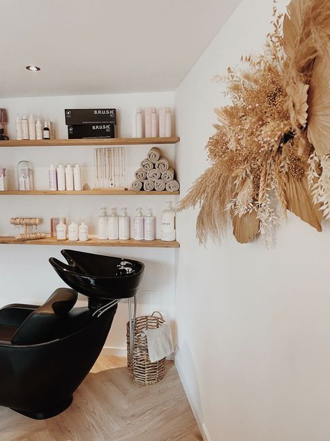 a hair salon with lots of products on the wall and shelves in front of it