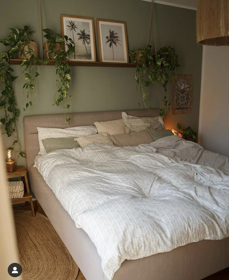 a bed with white sheets and pillows in a bedroom next to two framed pictures on the wall