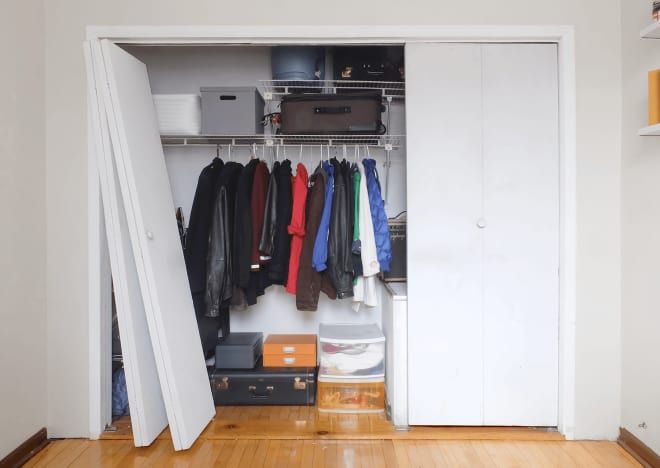 an open closet with clothes and other items