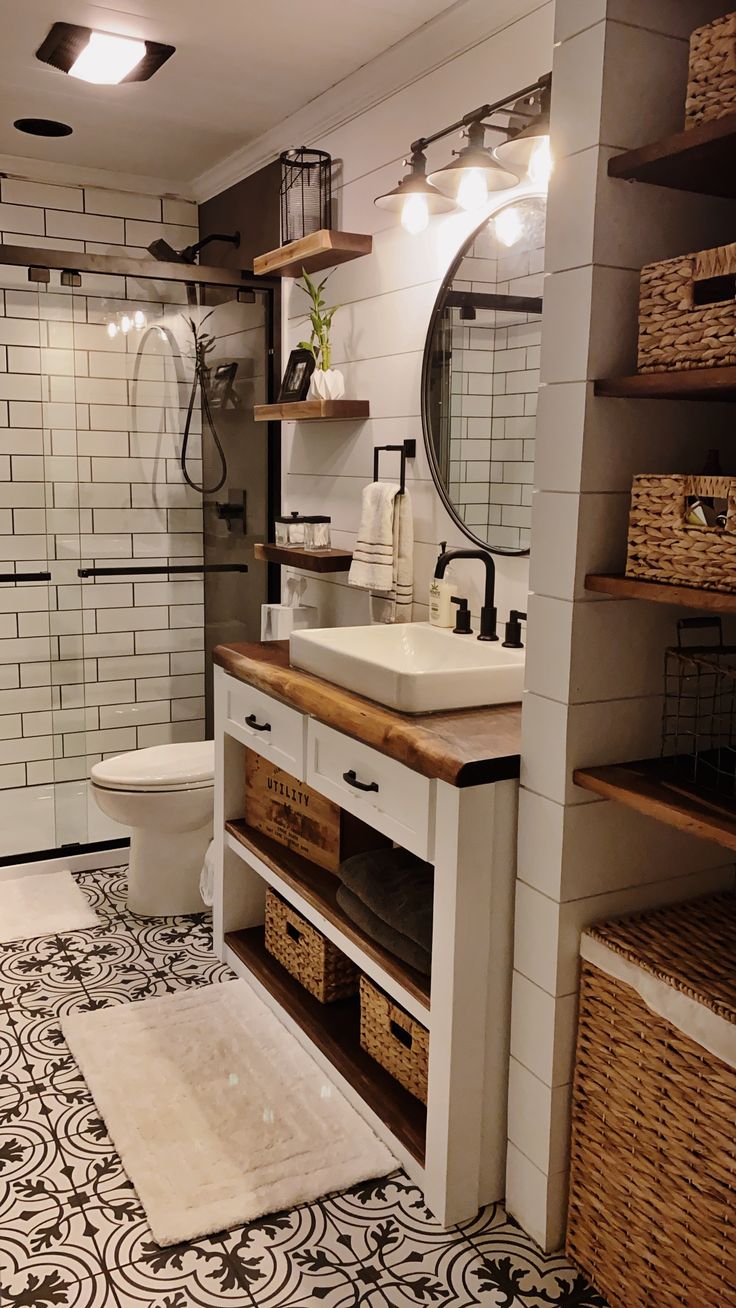 a bathroom with a sink, toilet and shower stall in the background is tiled flooring