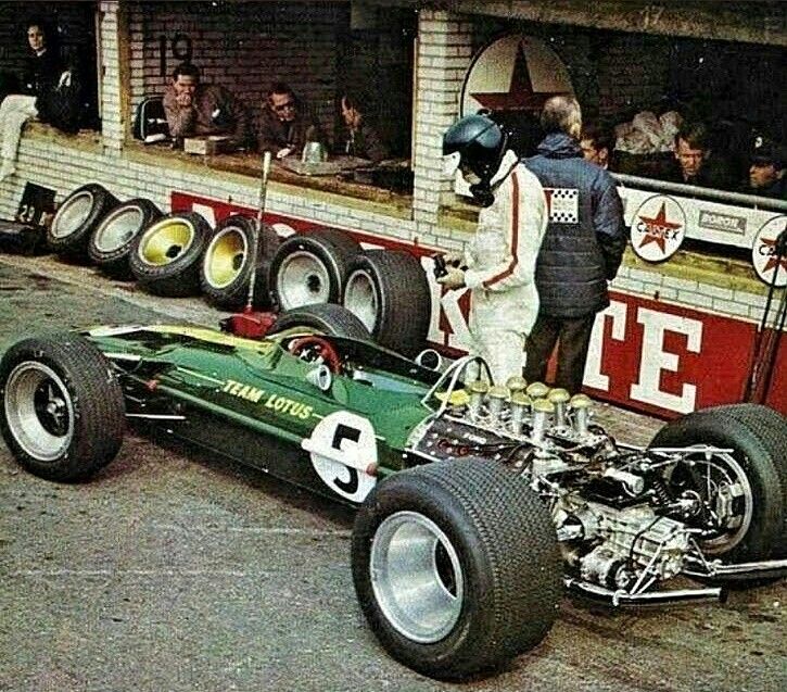 a man standing next to a green race car