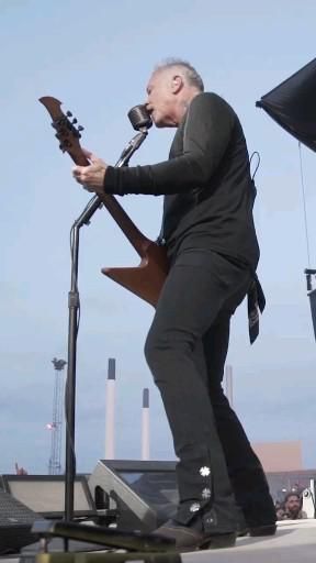 a man with a microphone and guitar on stage