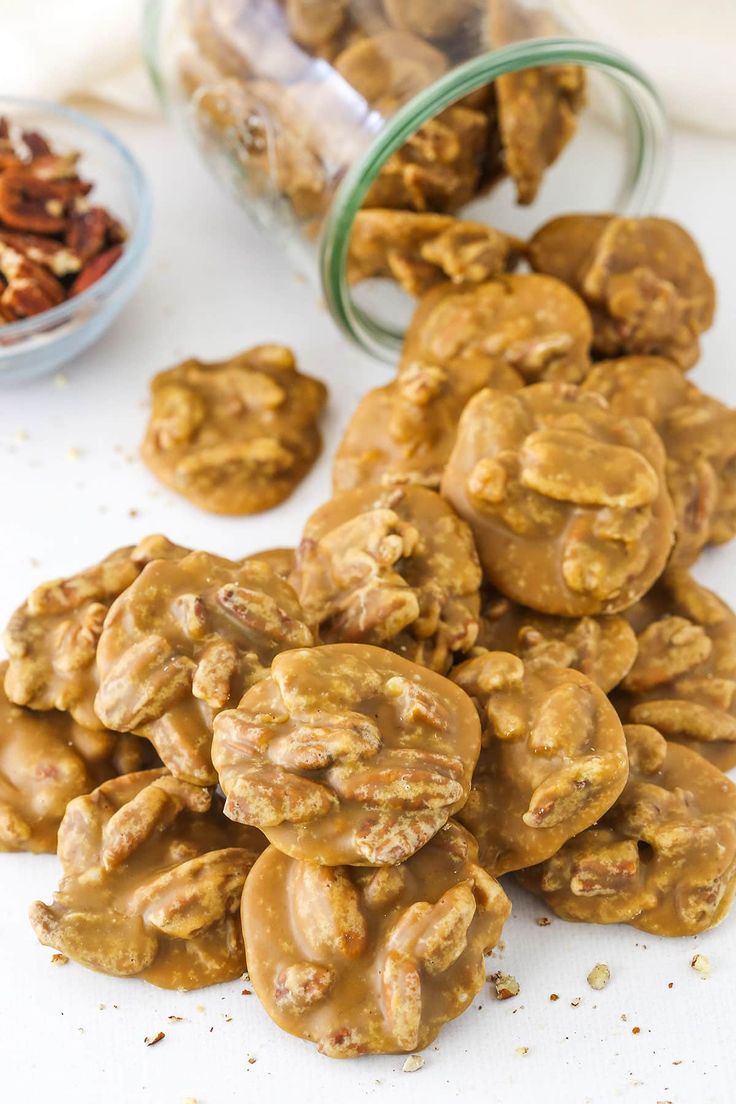 a pile of cookies sitting on top of a table next to a bowl of nuts