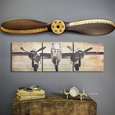 an airplane is hanging on the wall above a table with books and a clock in front of it