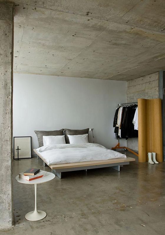 a bed sitting in the middle of a bedroom next to a table with a book on it