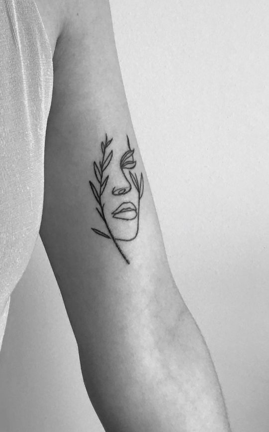 a woman with a face tattoo on her arm