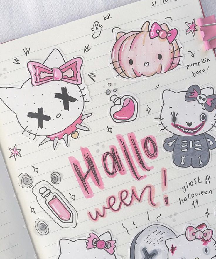 an open notebook with hello kitty stickers on the cover and writing in pink ink