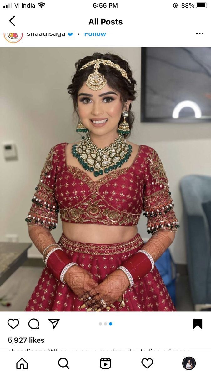 a woman in a red lehenga with gold jewelry on her neck and chest