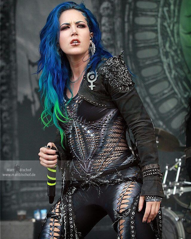 a woman with blue hair and piercings on stage