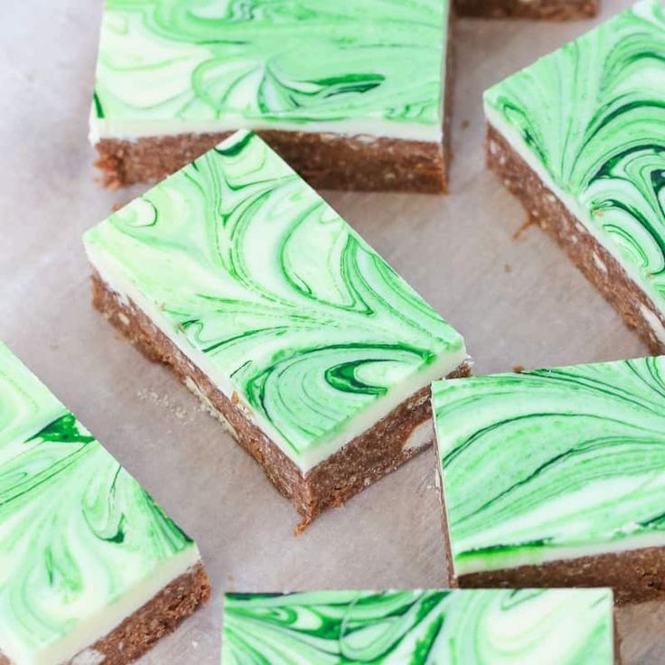 green and white marbled desserts are arranged on a piece of parchment paper, ready to be eaten