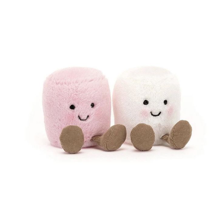 two small stuffed animals sitting next to each other on a white surface, one is pink and the other has brown feet