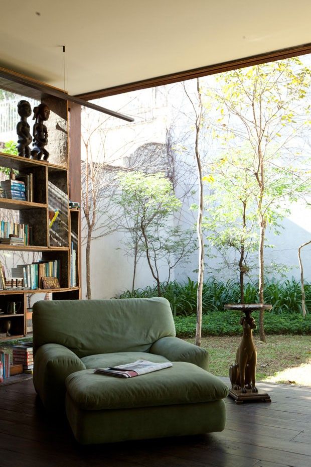 a green chair sitting in front of a book shelf filled with books