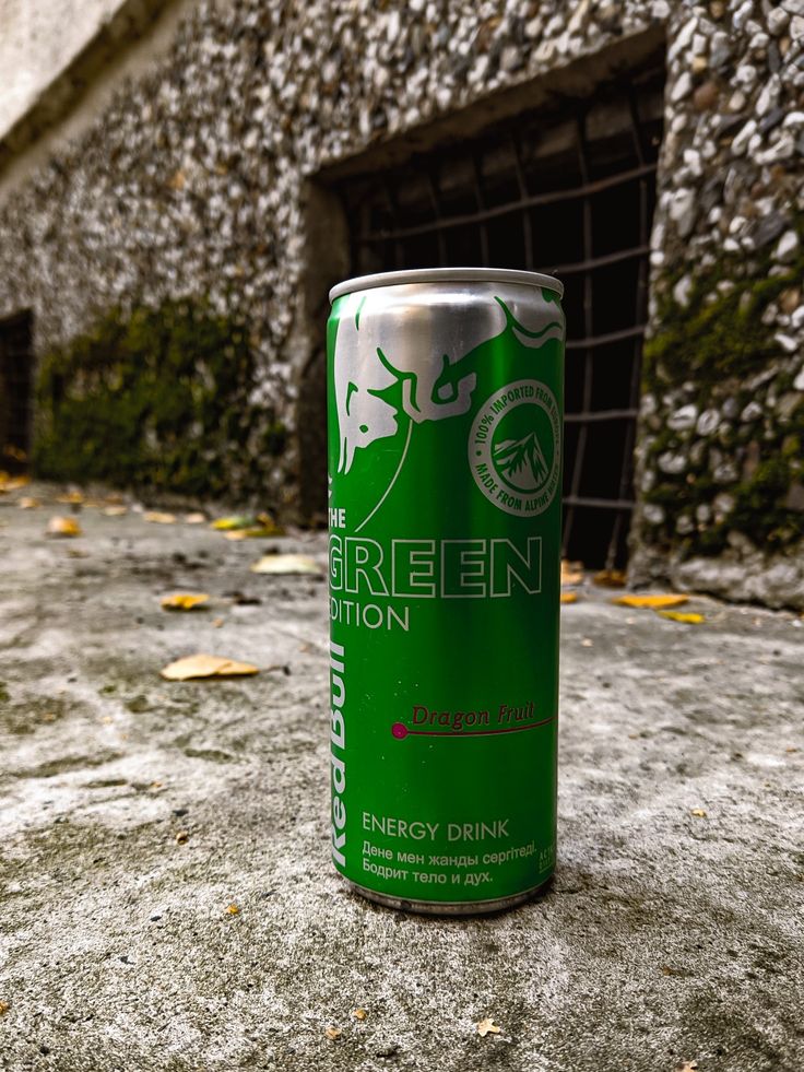 a can of energy drink sitting on the ground