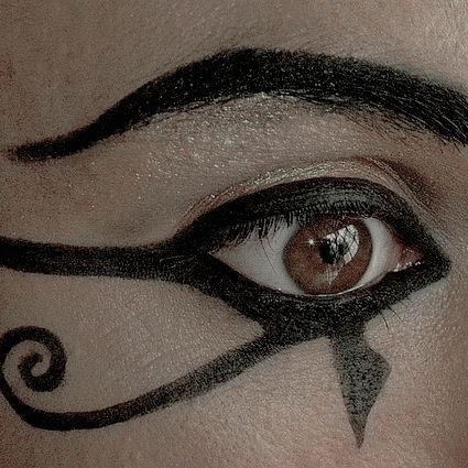 a woman's eye with black and white designs on her eyeshade, which is drawn in the shape of an arrow