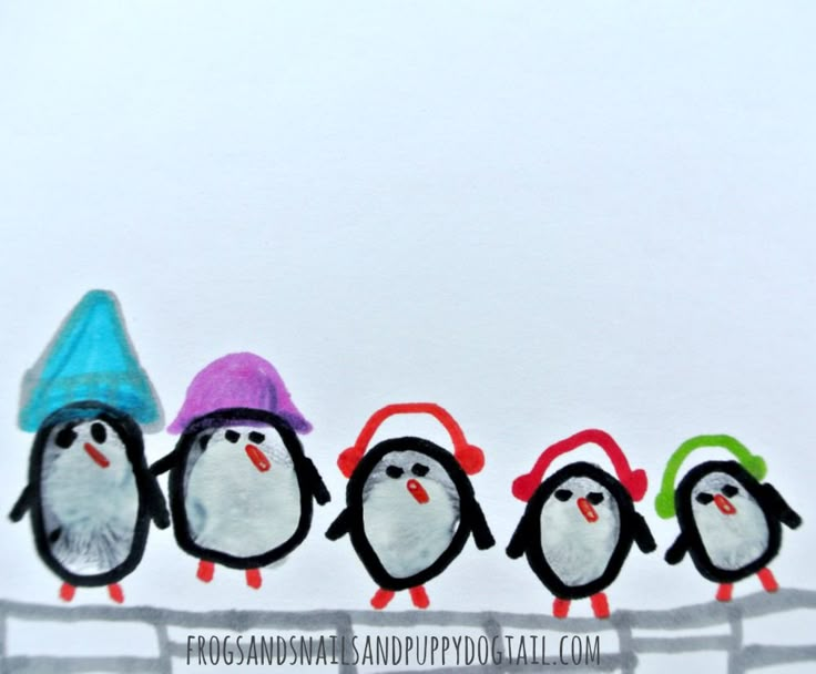 a group of penguins wearing hats on top of a fence