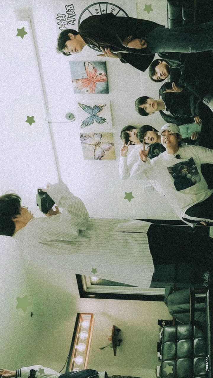 a group of people standing around each other in a room with stars on the wall