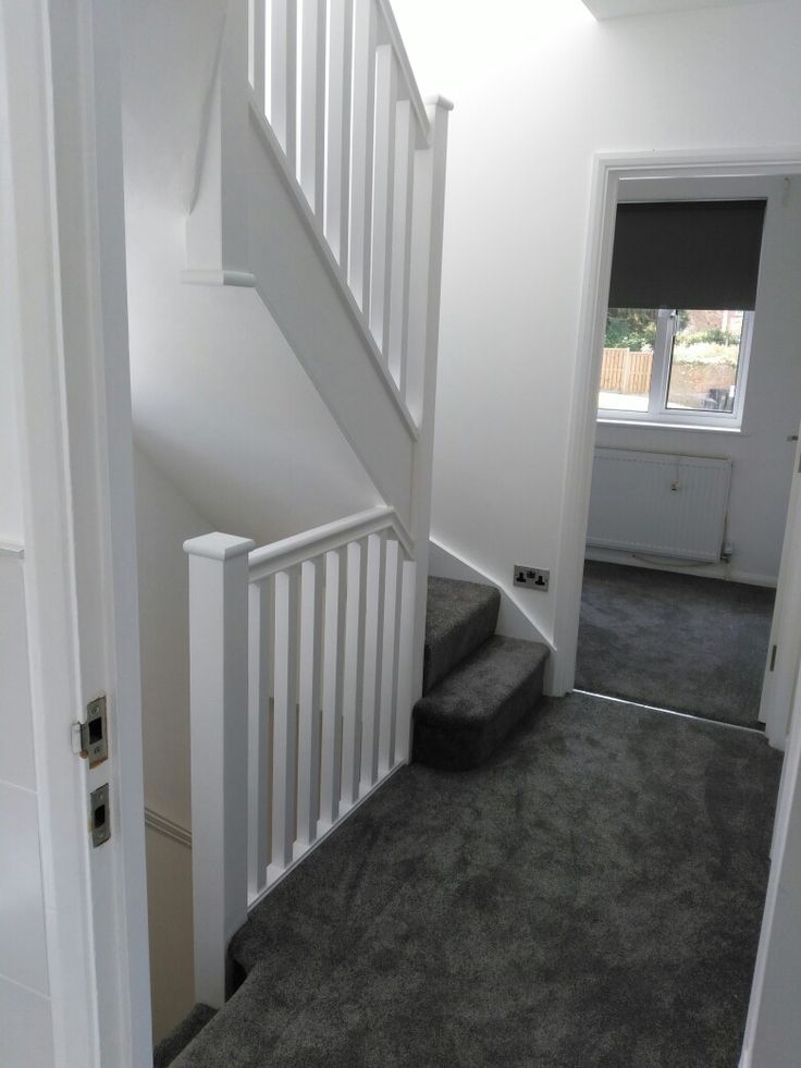 an empty room with stairs and carpeted flooring