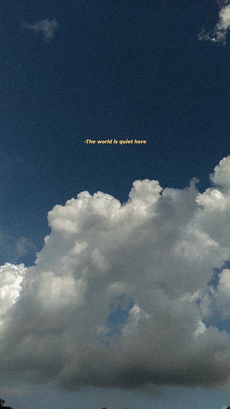 there is a plane flying in the sky with clouds behind it and an inscription on its side