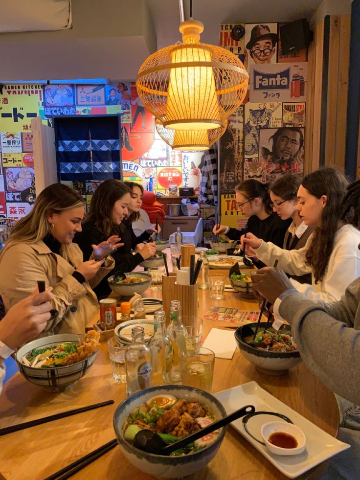 a group of people sitting around a table eating food