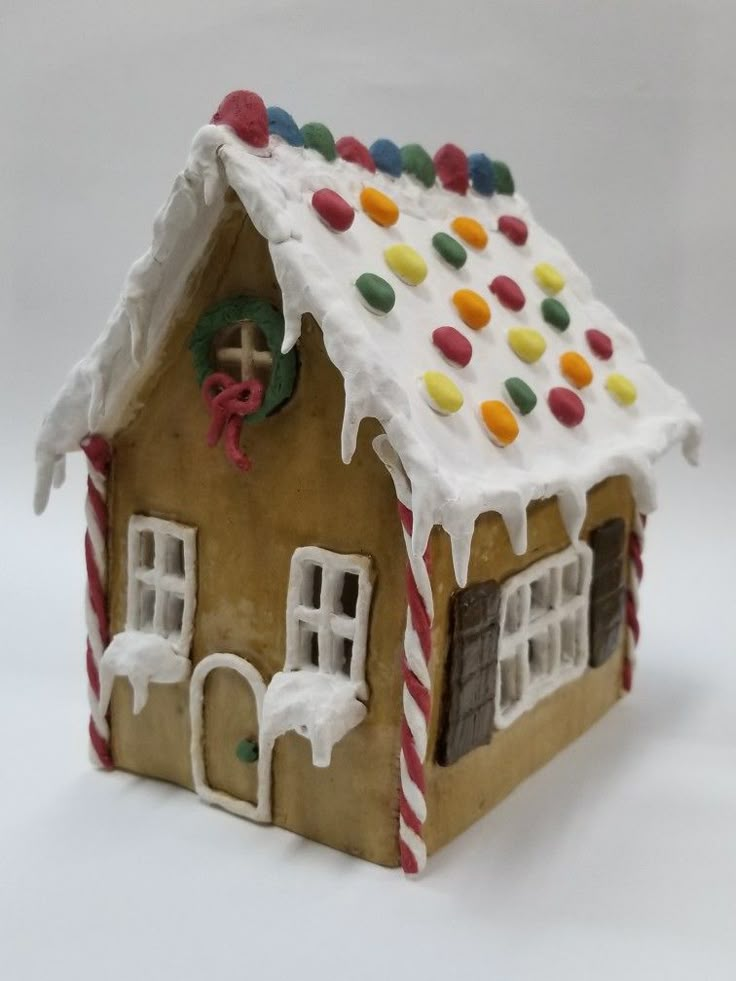 a gingerbread house decorated with candy and icing on the roof is shown in front of a white background