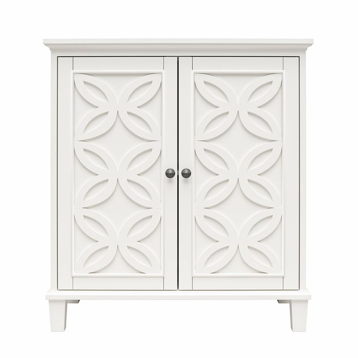 a white cabinet with two doors and an ornate design on the front, against a white background